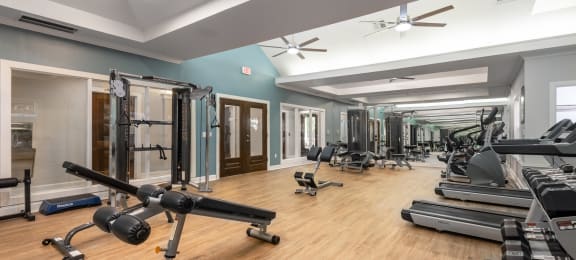 2200 sq ft gym with cardio equipment and weights on a wood floor