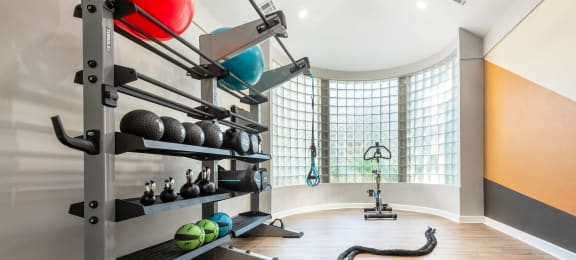 a workout room with weights and a gym ball on the floor and a large window
