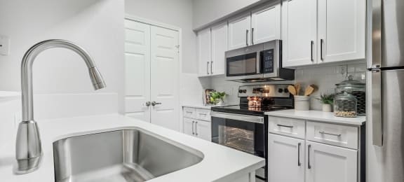 our spacious kitchen is equipped with stainless steel appliances and white cabinets