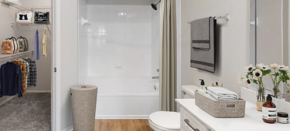 a bathroom with a white toilet next to a white bathtub with a shower curtain