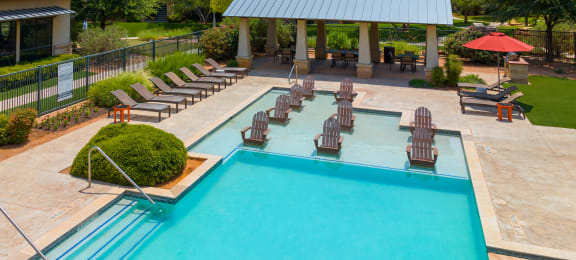 a swimming pool with lounge chairs and umbrellas