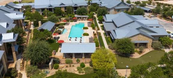 an aerial view of a house with a swimming pool in the backyard