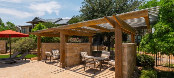 a patio with a pergola and patio furniture