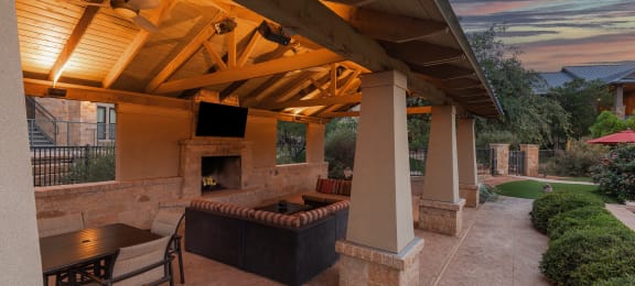 a covered patio with a fireplace and a tv
