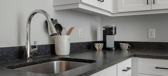 a kitchen counter with a sink and a coffee maker