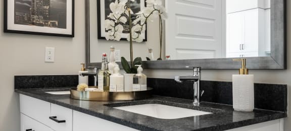 a black and white bathroom with a sink and a mirror