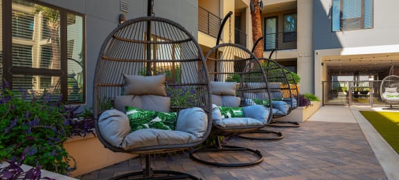 a row of swinging chairs in a courtyard