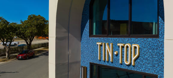 the front of the tin top building with a blue and gold sign