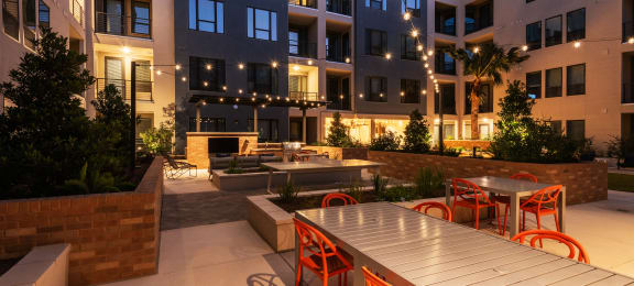 an outdoor patio with tables and chairs at an apartment building