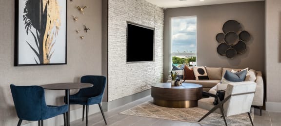 a living room with a couch table and chairs and a flat screen tv on the wall