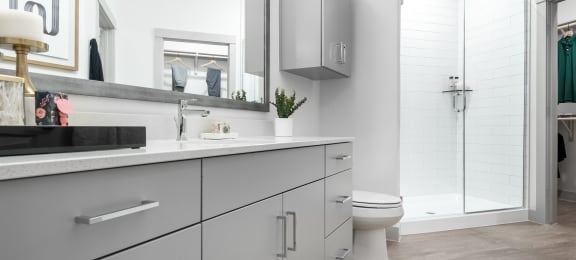 a bathroom with white cabinets and a white toilet