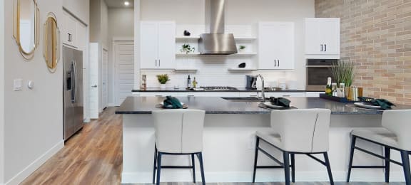 a kitchen with white cabinetry and a large island with a breakfast bar