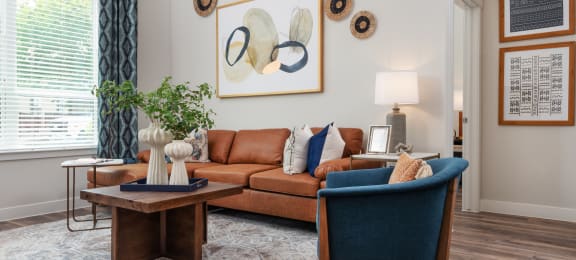 a living room with a brown couch and blue chairs