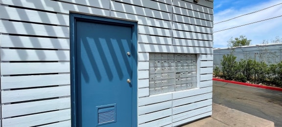 a blue door on a white building with a white awning above it