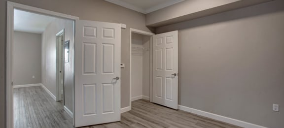 a bedroom with two doors and a door to a bathroom