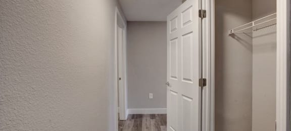 a hallway with an open door and a closet