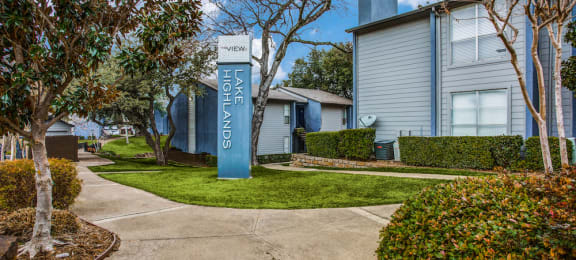 a sidewalk with a blue welcome sign in front of a house