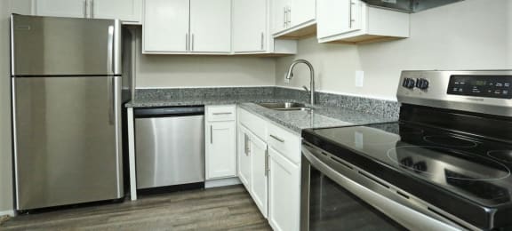Kitchen with granite counters, stainless appliances, and white cabinets