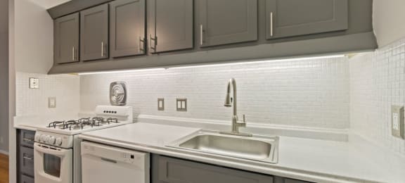 a kitchen with white appliances and gray cabinets