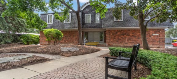 a brick house with a brick walkway and a bench