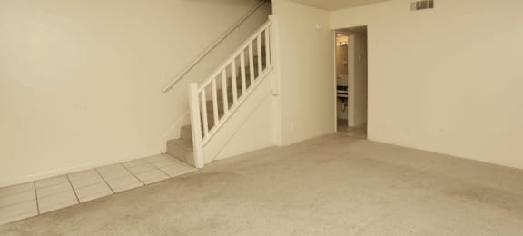Carpeted living room with stairs