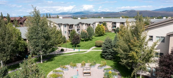 Aerial view of a courtyard with trees and community garden beds at Mullan Reserve Apartments in Missoula, MT