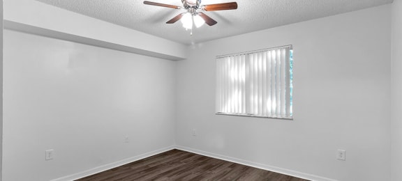 Bedroom with ceiling fan and window at Cedar Grove Apartments in Miami Gardens FL