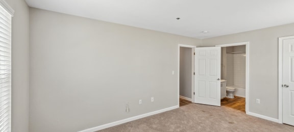 Carpeted bedroom with en suite at England Run Apartments in Fredericksburg VA