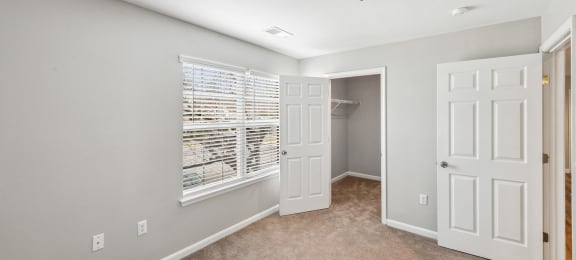 Bedroom with walk in closet and carpet at England Run Apartments in Fredericksburg VA
