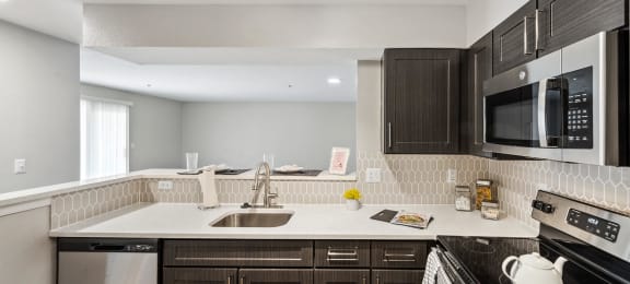 Kitchen with white counters and dark cabinets at England Run Apartments in Fredericksburg VA