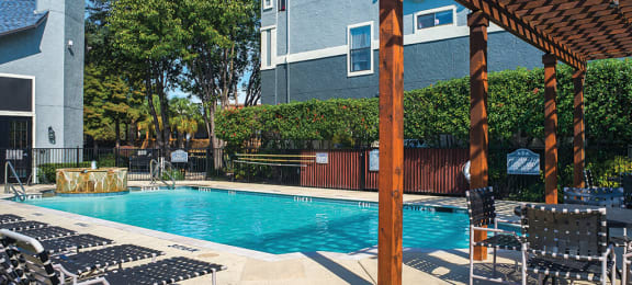 North Dallas TX Apartments - Tivoli Apartments - Relaxing Pool wth Lounge Chairs, Pergola, Table and Chairs