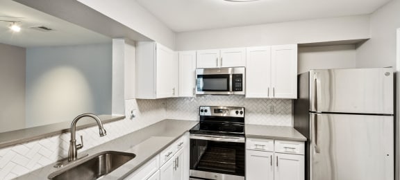 Kitchen with fridge and white cabinets at England Run Apartments in Fredericksburg VA