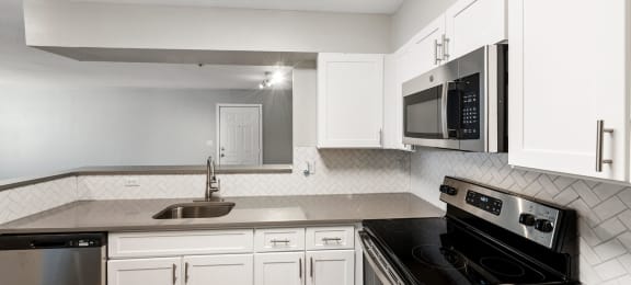 Kitchen with white cabinets and oven at England Run Apartments in Fredericksburg VA