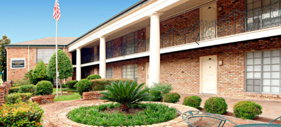 Apartments near the Galleria with brick exteriors, beautiful landscaping and courtyard setting at Plantation apartments in Houston.