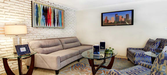 Spacious living room with white brick feature wall at Plantation apartments near the Galleria in Houston.