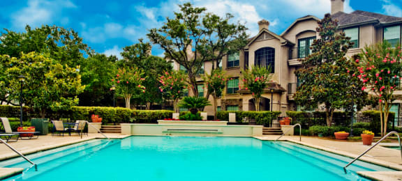 Luxury swimming pool with poolside lounges, 2 resort-style swimming pools with spa, beautiful landscaping, lush landscaping at Village on the Parkway Apartments.