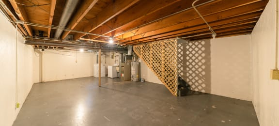 the basement of a building with a concrete floor and wood ceilings
