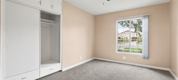 One Bedroom Apartments with Van Nuys, CA - Colonial Manor Spacious Bedroom with Carpet Flooring, Large Closet, and Ceiling Fan