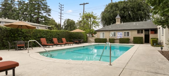 Apartments in Van Nuys, CA - Colonial Manor Swimming Pool with Lounge Chairs and Umbrella Covered Table Seating