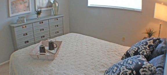 a bedroom with a bed, dresser, and a window  at Valley York Apartments, Parma Heights, 44130