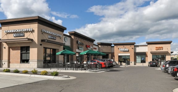 a rendering of the front of a shopping center with cars parked outside at Bluestone Lofts, Duluth, Minnesota