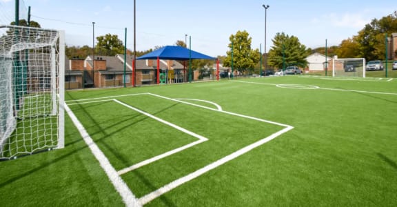 a soccer field at a school with a soccer goal on it