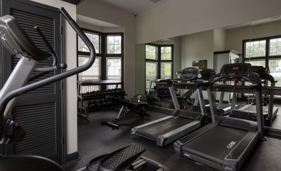 a gym with cardio equipment and weights in a building