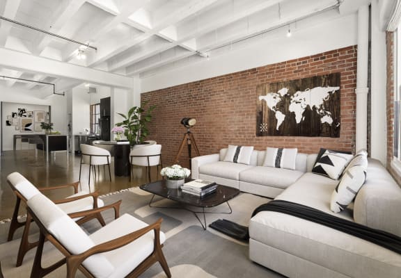 Living room with a white couch and a brick wall at South Park Lofts, California