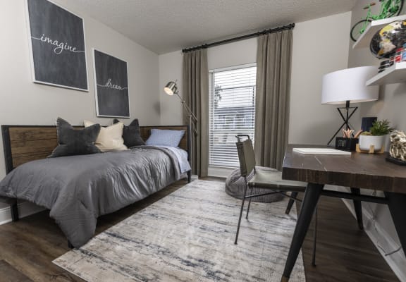 a bedroom with a bed and desk in a 555 waverly unit
