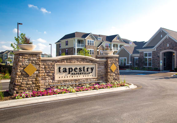 a sign that says tapestry apartments in front of a row of houses