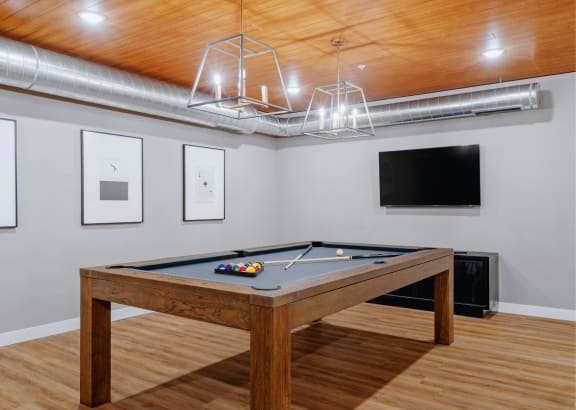 a game room with a pool table and a flat screen tv