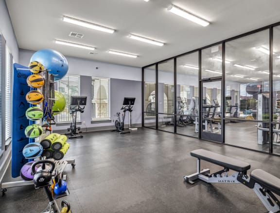 a gym with weights and cardio equipment and glass walls