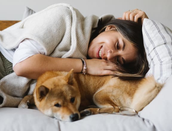 a woman laying in bed with her dog