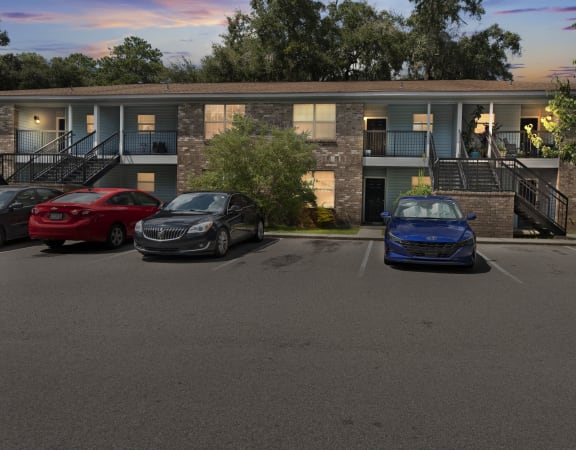 a parking lot with three cars in front of a building